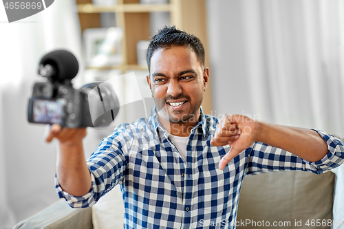 Image of male video blogger with camera blogging at home