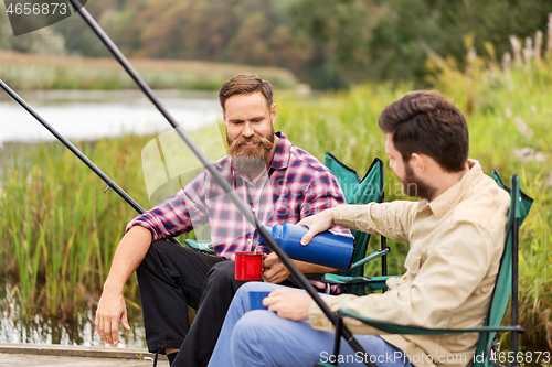 Image of friends fishing and drinking tea from thermos