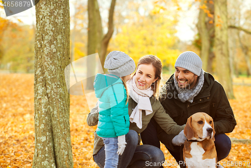 Image of happy family with beagle dog in autumn park
