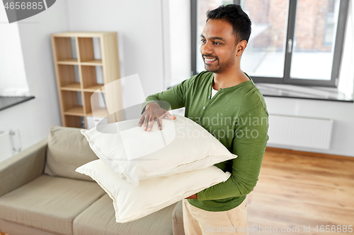 Image of indian man with sofa cushions at new home