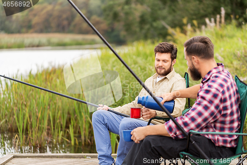 Image of friends fishing and drinking tea from thermos