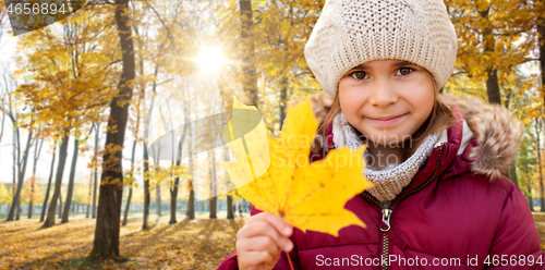 Image of happy girl with fallen maple leaf at autumn park