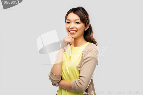 Image of happy asian woman over grey background