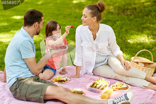 Image of family eating strawberries on picnic at park