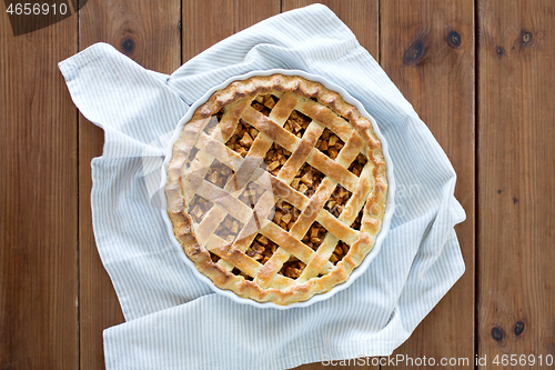 Image of close up of apple pie in mold on wooden table