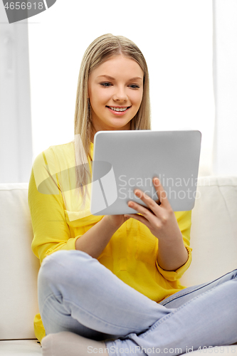 Image of young woman or teenage girl with tablet pc at home