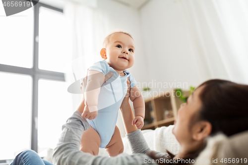 Image of happy mother with little baby son at home