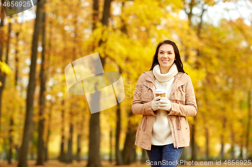 Image of woman drinking takeaway coffee in autumn park