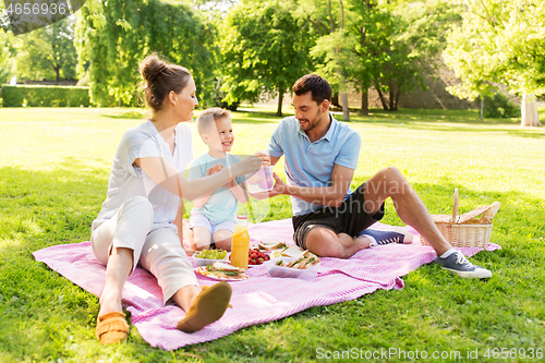 Image of happy family having picnic at summer park