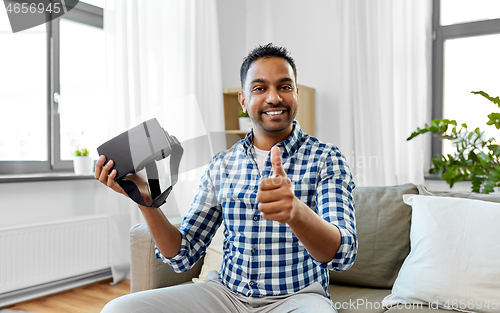 Image of male blogger with vr glasses videoblogging at home