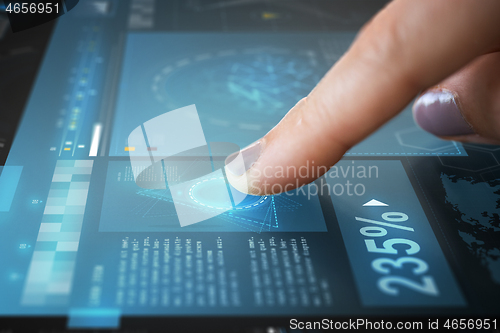 Image of finger on touch screen with virtual data