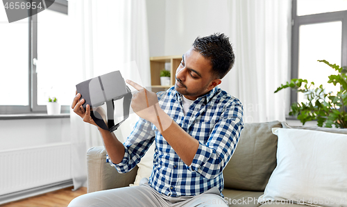 Image of male blogger with vr glasses videoblogging at home