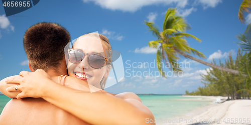 Image of happy couple hugging on summer beach