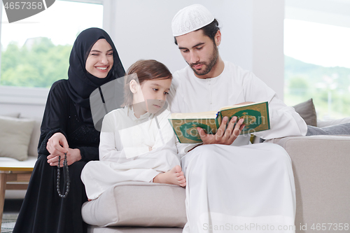 Image of muslim family reading Quran and praying at home