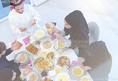 Image of traditional muslim family praying before iftar dinner