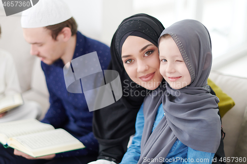 Image of muslim family reading Quran and praying at home