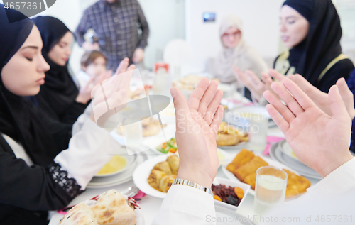 Image of traditional muslim family praying before iftar dinner