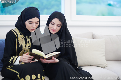 Image of young muslim women reading Quran at home