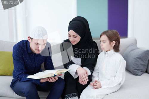 Image of muslim family reading Quran and praying at home