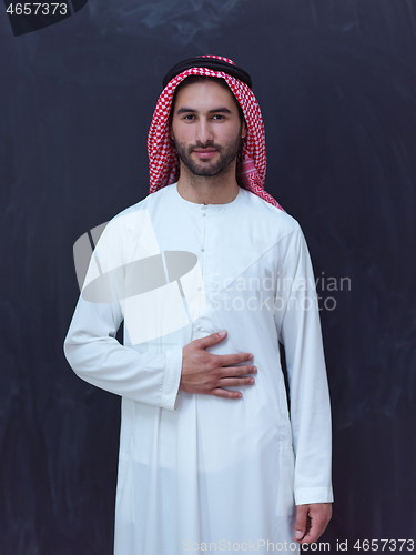 Image of portrait of arabian man in front of black chalkboard