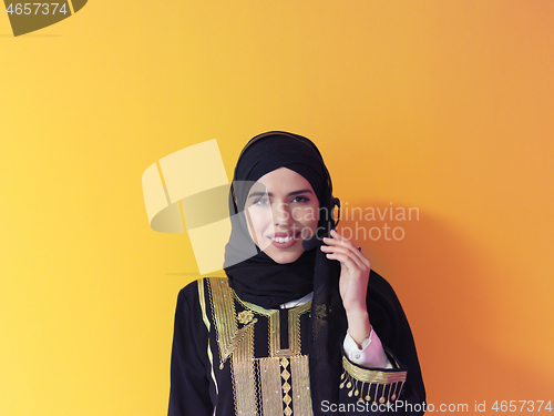 Image of portrait of muslim woman with headset on yellow background