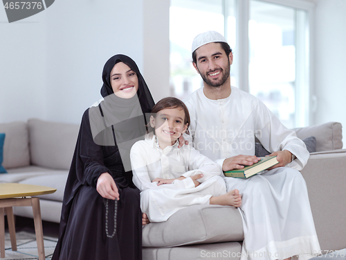 Image of muslim family reading Quran and praying at home