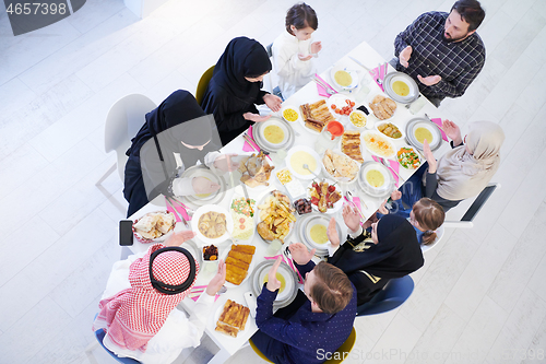 Image of traditional muslim family praying before iftar dinner