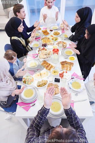 Image of traditional muslim family praying before iftar dinner