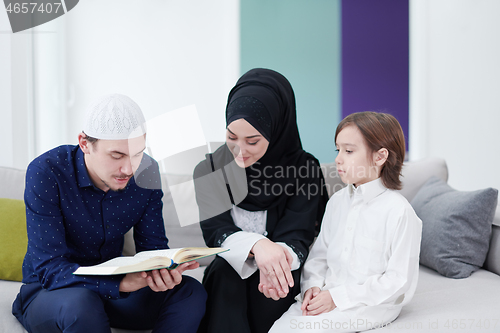 Image of muslim family reading Quran and praying at home