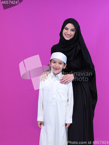 Image of portrait of muslim mother and son on pink background