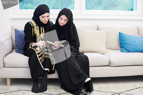 Image of young muslim women reading Quran at home