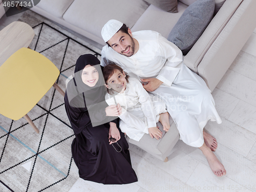 Image of muslim family reading Quran and praying at home