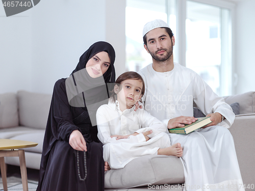 Image of muslim family reading Quran and praying at home