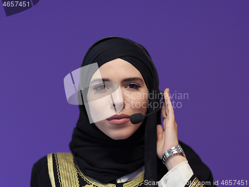 Image of portrait of muslim woman with headset on purple background