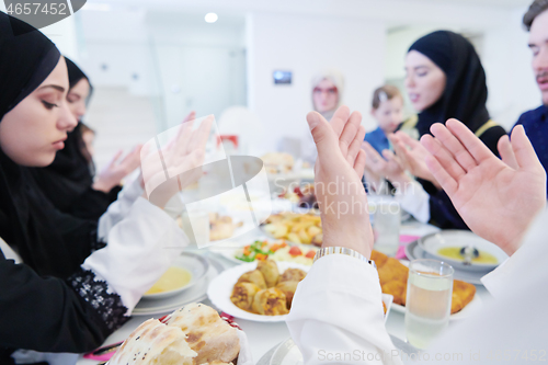 Image of traditional muslim family praying before iftar dinner