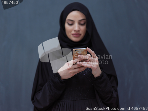 Image of young modern muslim business woman using smartphone