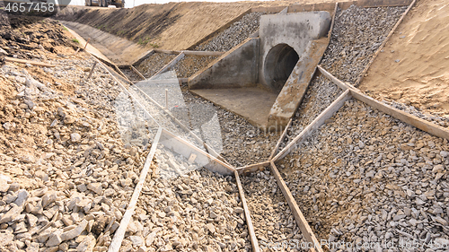 Image of Construction of a drainage ditch along a road with a culvert under the road