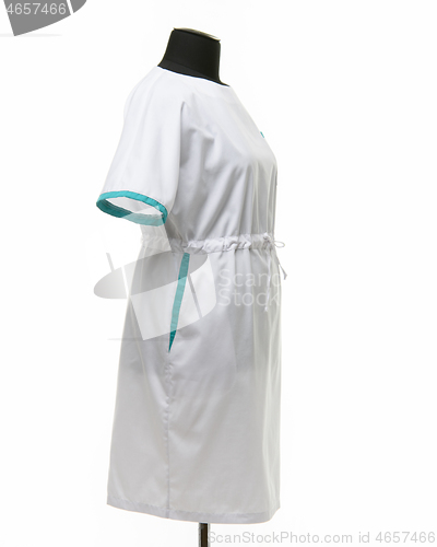 Image of Side view of a female medical gown on a mannequin for clothes on a white background