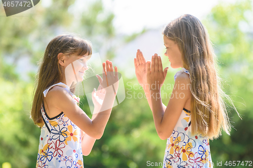 Image of Children play ladlets walking in a city park, close-up