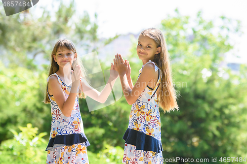 Image of Children play in the frogs walking in the city park, and looked into the frame