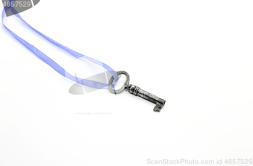 Image of Vintage silver key on blue ribbon on white background