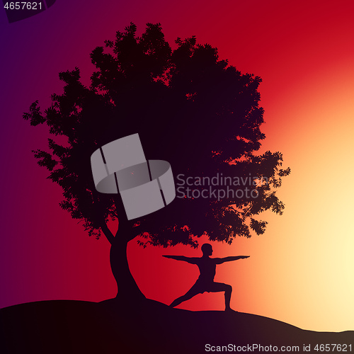 Image of man doing yoga under a tree in the sunset