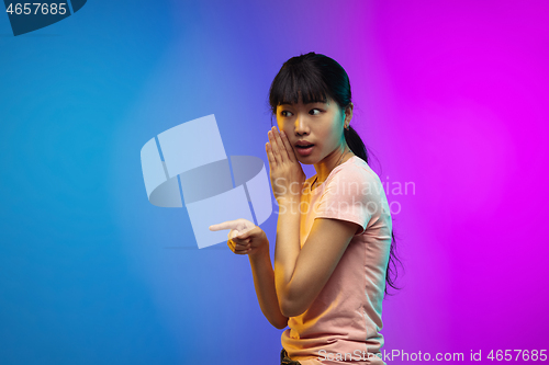 Image of Asian young woman\'s portrait on gradient studio background in neon