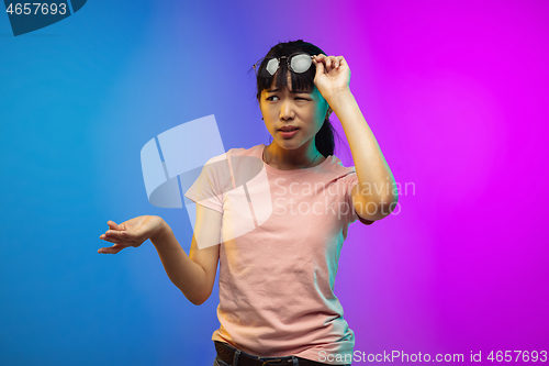 Image of Asian young woman\'s portrait on gradient studio background in neon