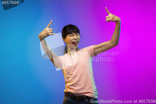 Image of Asian young woman\'s portrait on gradient studio background in neon