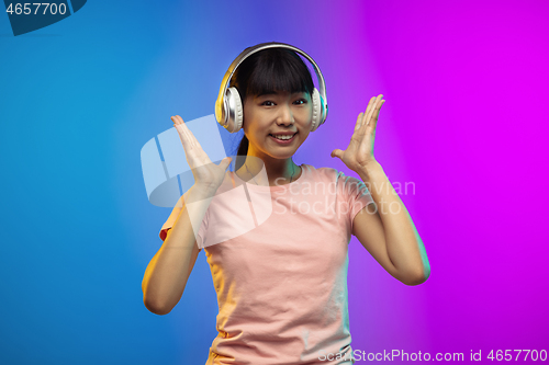 Image of Asian young woman\'s portrait on gradient studio background in neon