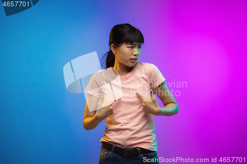 Image of Asian young woman\'s portrait on gradient studio background in neon