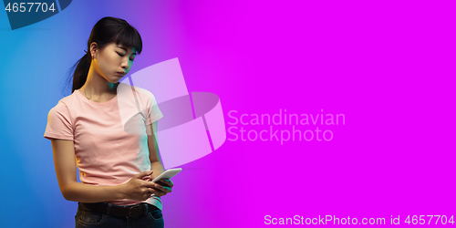 Image of Asian young woman\'s portrait on gradient studio background in neon