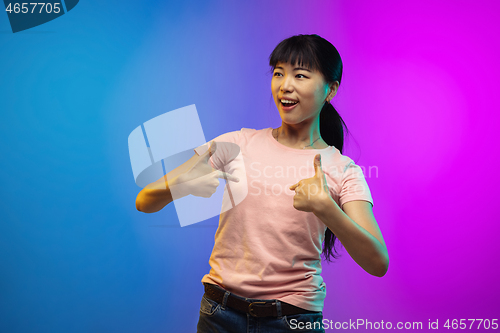 Image of Asian young woman\'s portrait on gradient studio background in neon