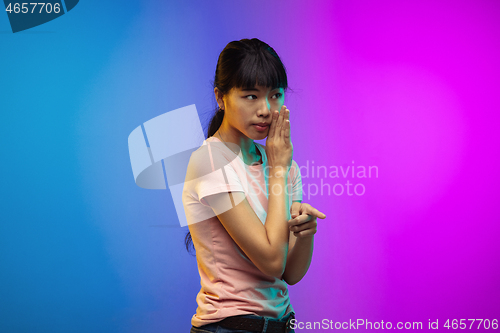 Image of Asian young woman\'s portrait on gradient studio background in neon